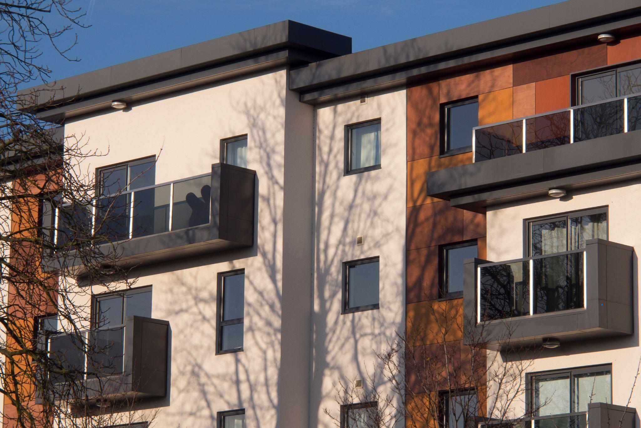 A modern apartment block with balconies and timber cladding