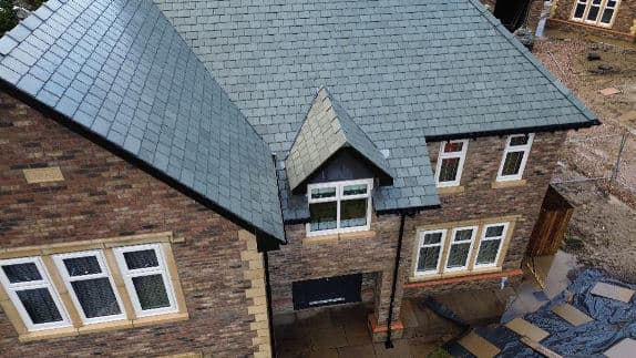 Aerial view of a slate-roofed new-build house
