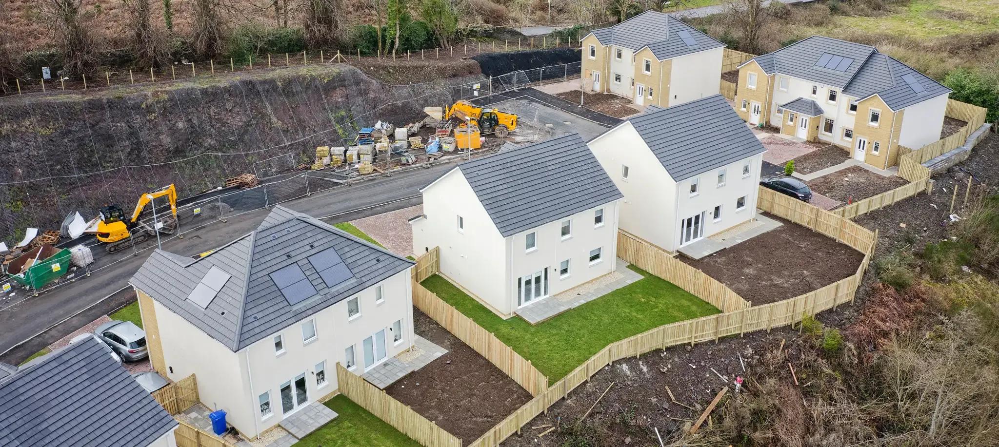 Aerial view of white-rendered new-build houses on a sloping site
